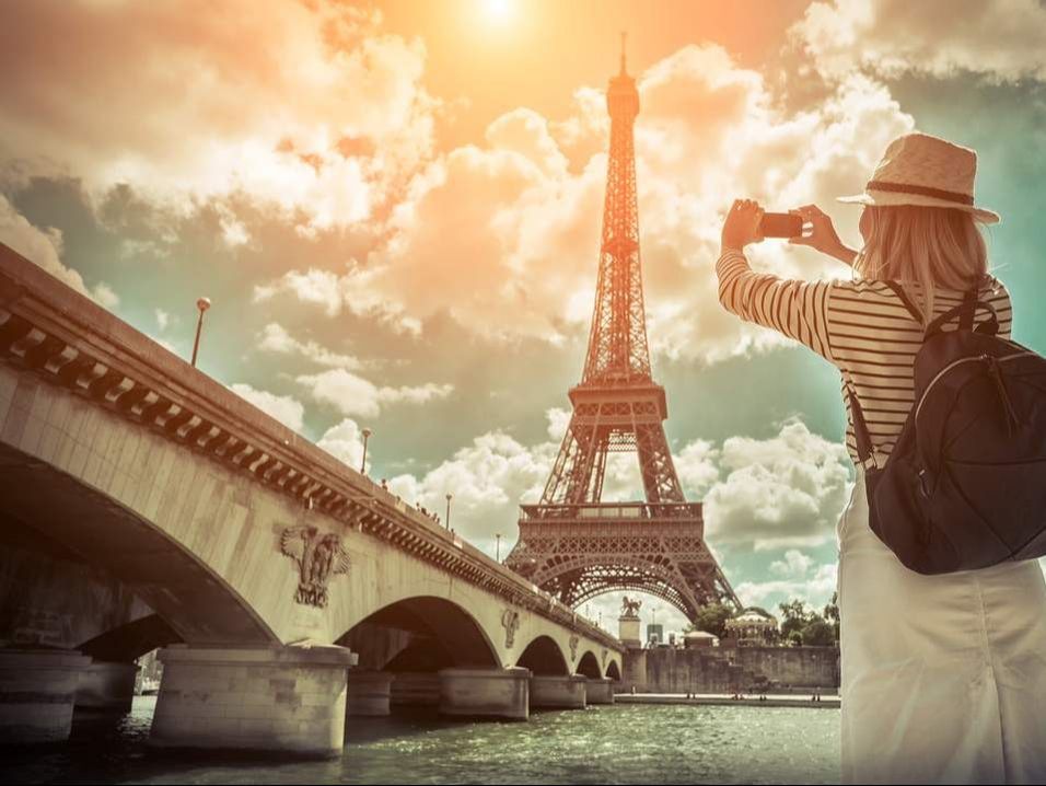 Woman taking picture of Eiffel Tower